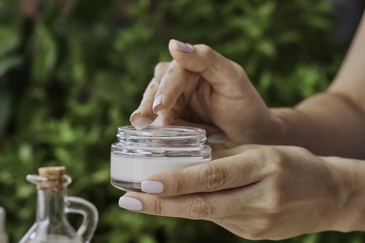 Hands applying a topical cream
